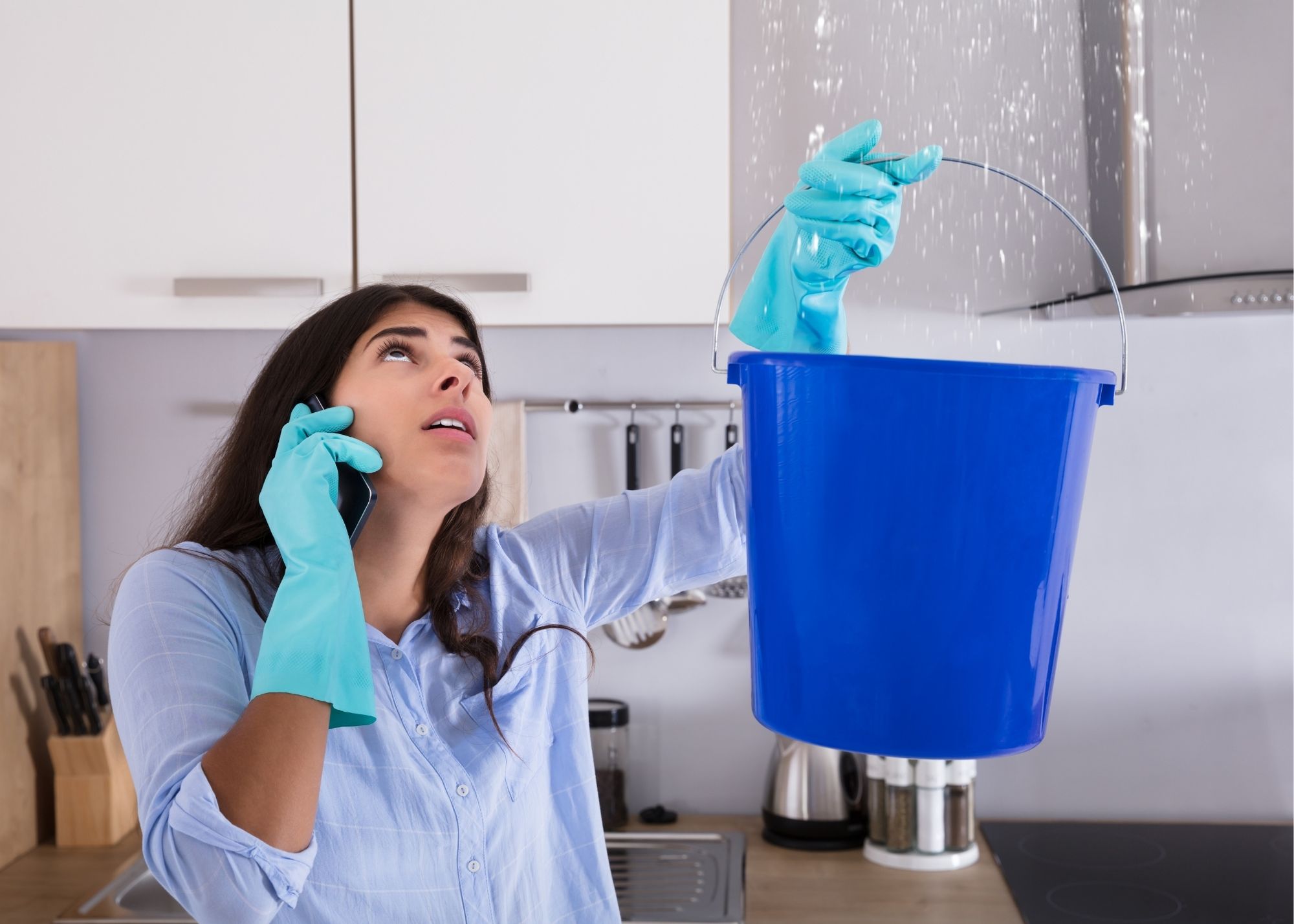 Bucket catching drips from a water-damaged ceiling in an Overland Park home