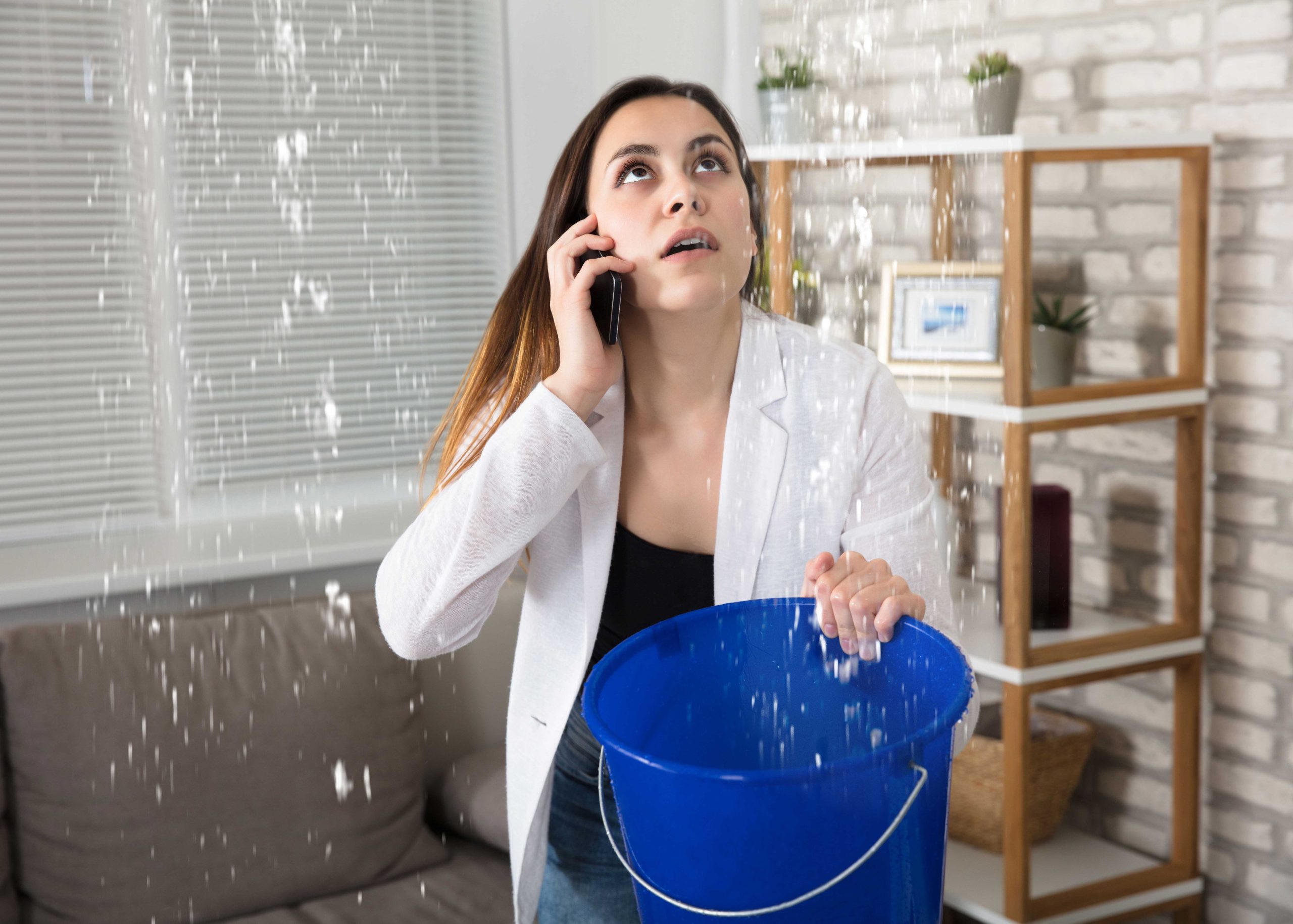 Bucket catching a leak from a burst pipe in an Overland Park ceiling